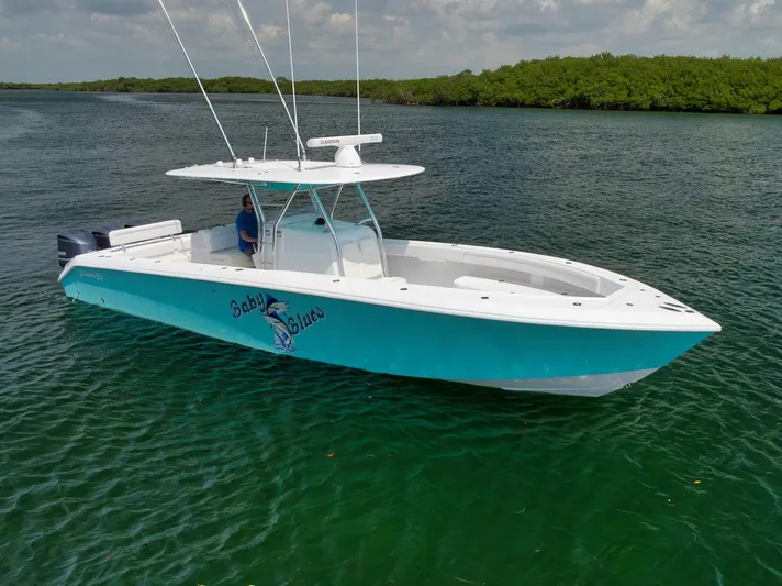 Baby Blues Yacht Photos Pics 2013 Bahama 37 boat on calm water, featuring a sleek design and vibrant blue hull.