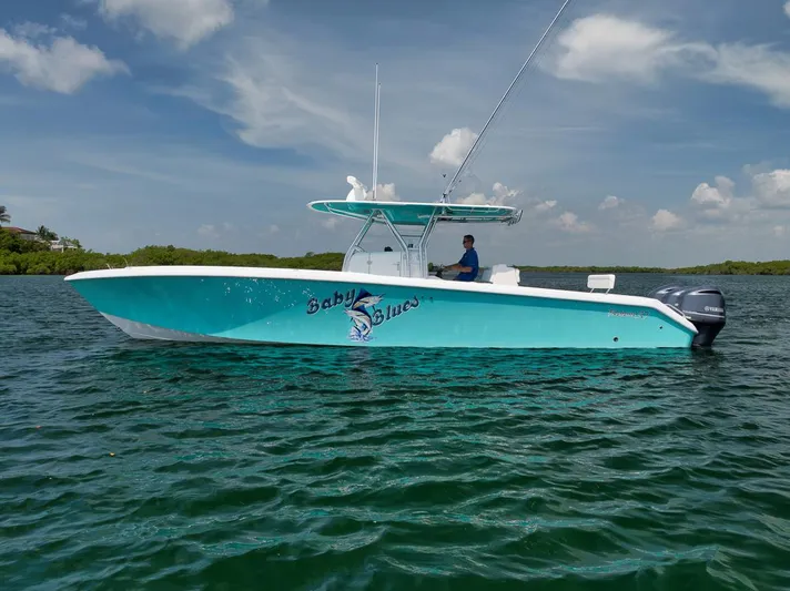 Baby Blues Yacht Photos Pics 2013 Bahama 37 boat on water, turquoise hull, clear sky background.