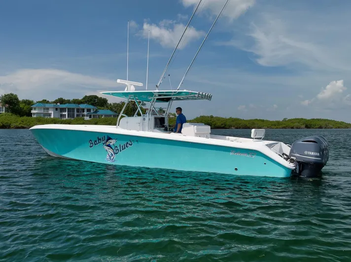 Baby Blues Yacht Photos Pics 2013 Bahama 37 boat on water, turquoise hull, Yamaha engine, clear sky background.