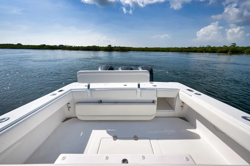 Baby Blues Yacht Photos Pics 2013 Bahama 37 boat on calm water, clear sky, rear view.