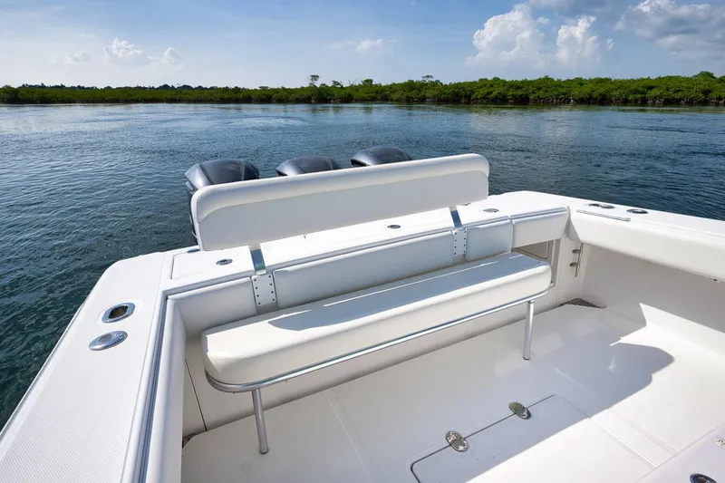 Baby Blues Yacht Photos Pics 2013 Bahama 37 boat with seating, on calm water, clear sky background.