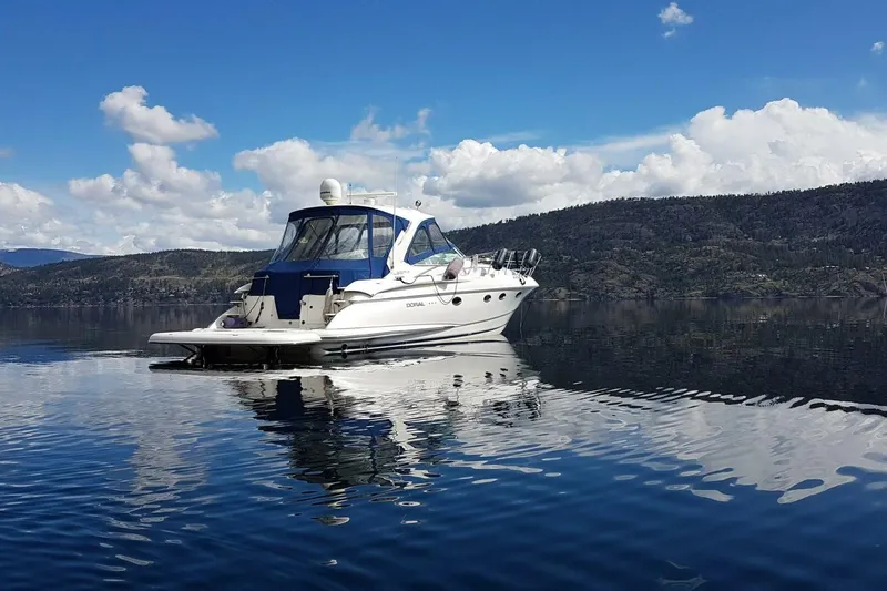  Yacht Photos Pics 2005 Doral Alegria boat on calm lake with scenic mountain backdrop.