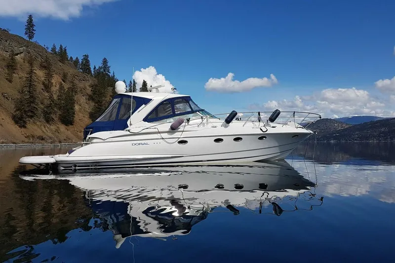  Yacht Photos Pics 2005 Doral Alegria yacht on serene lake with clear blue sky and forested hills.