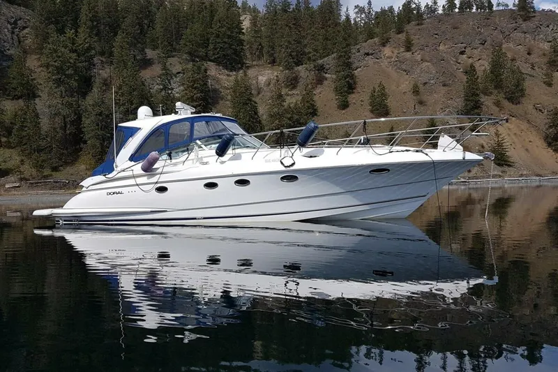  Yacht Photos Pics 2005 Doral Alegria yacht on calm water, surrounded by forested hills.