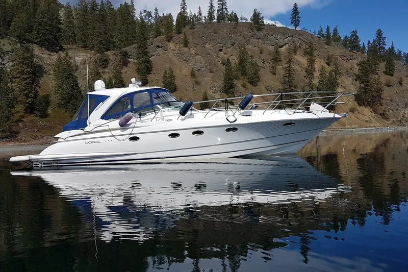  Yacht Photos Pics 2005 Doral Alegria yacht on calm water with forested hillside background.