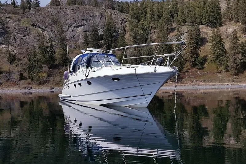  Yacht Photos Pics 2005 Doral Alegria boat on calm lake with forested hills in background.