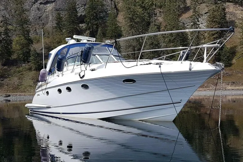  Yacht Photos Pics 2005 Doral Alegria yacht on calm water, surrounded by forested cliffs.