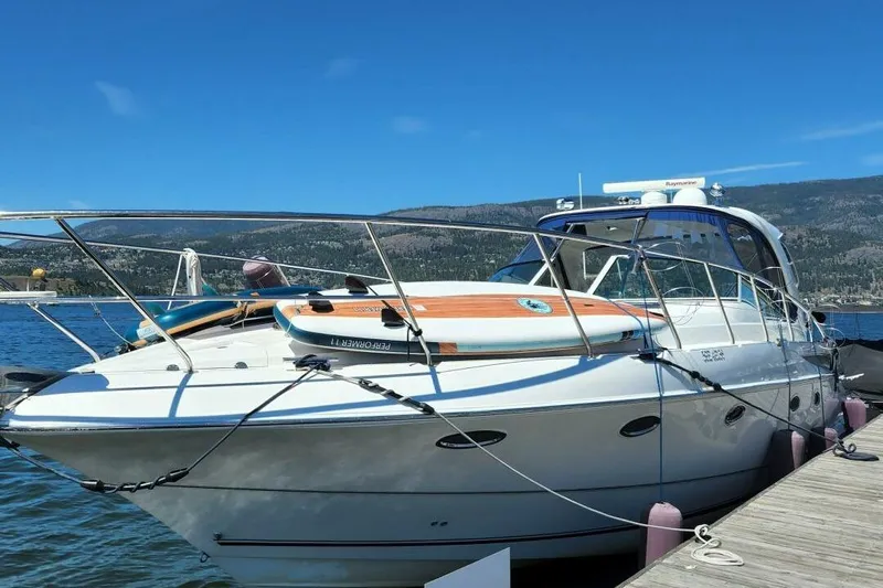  Yacht Photos Pics 2005 Doral Alegria boat docked with paddleboards, scenic mountain backdrop.