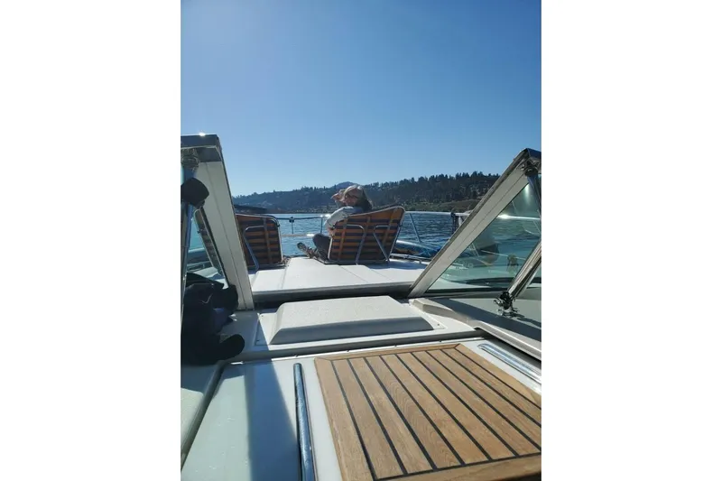  Yacht Photos Pics 2005 Doral Alegria boat cruising on a sunny lake with scenic forest views.