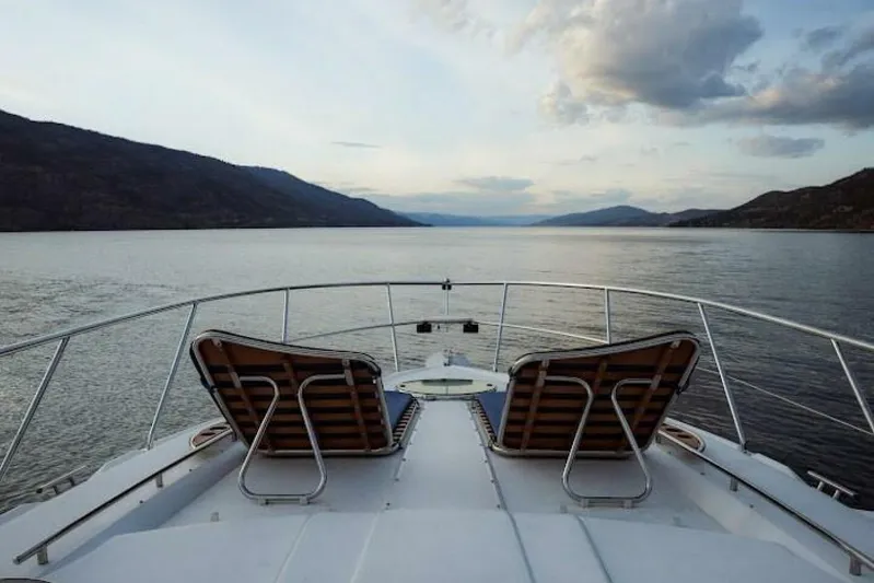  Yacht Photos Pics 2005 Doral Alegria boat with deck chairs, scenic lake view, and mountains.