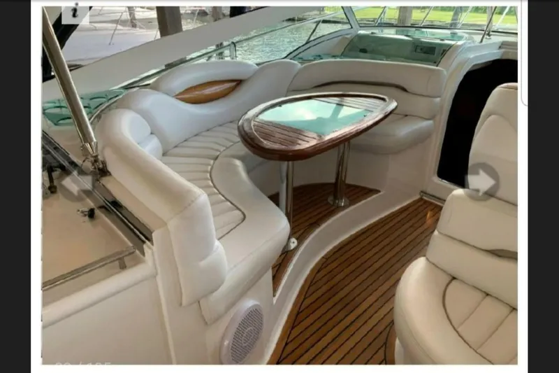  Yacht Photos Pics Luxurious interior of 2005 Doral Alegria yacht with white seating and wooden table.