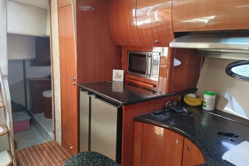  Yacht Photos Pics 2005 Doral Alegria yacht interior with kitchenette, featuring wood cabinetry and modern appliances.