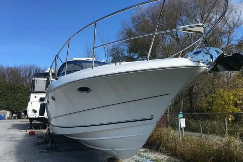  Yacht Photos Pics 2005 Doral Alegria boat on dry dock, surrounded by trees and clear blue sky.