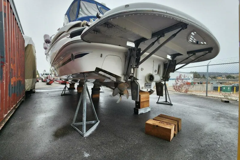  Yacht Photos Pics 2005 Doral Alegria boat on stands in a storage yard, showing propellers and hull.