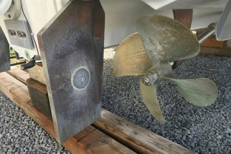  Yacht Photos Pics 2005 Doral Alegria boat propeller and rudder on gravel and wooden supports.