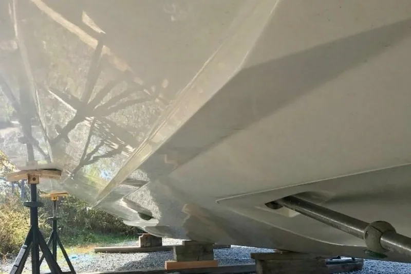  Yacht Photos Pics 2005 Doral Alegria boat hull on stands, reflecting sunlight, outdoors.