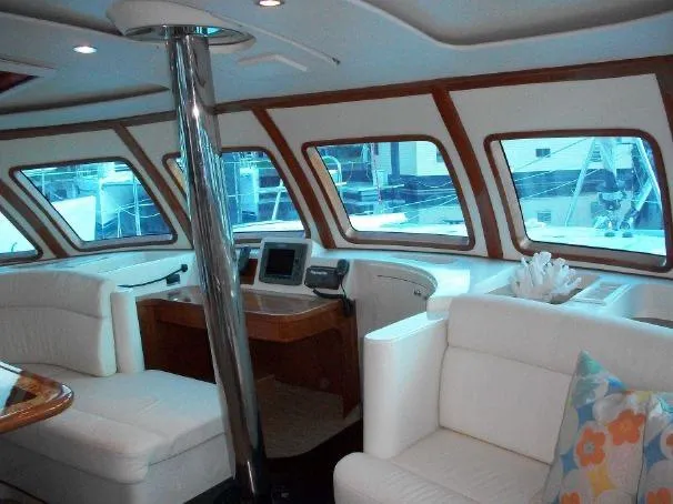 Que Sera Yacht Photos Pics Luxurious interior of 2009 Prout 45S yacht with white seating and large windows.