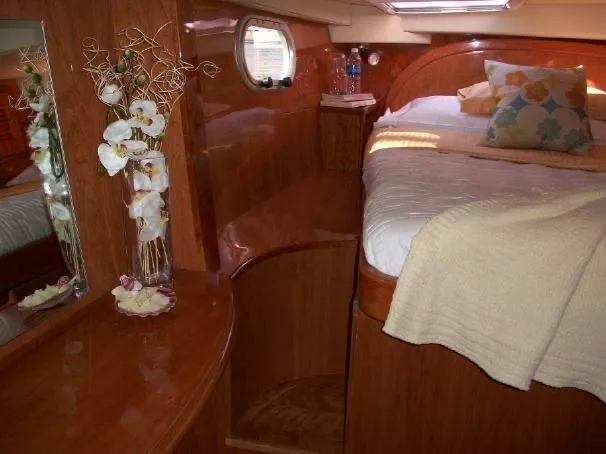 Que Sera Yacht Photos Pics Luxurious cabin interior of 2009 Prout 45S yacht with elegant wood finish and cozy bedding.