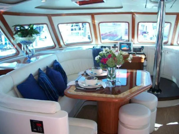 Que Sera Yacht Photos Pics Luxurious interior of 2009 Prout 45S yacht with elegant dining area and floral centerpiece.