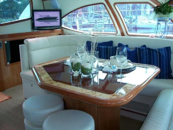 Que Sera Yacht Photos Pics Luxurious interior of 2009 Prout 45S yacht with elegant dining area and scenic marina view.