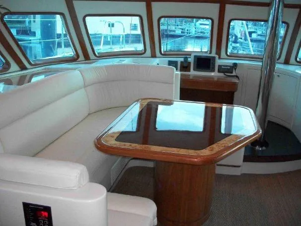 Que Sera Yacht Photos Pics Luxurious interior of a 2009 Prout 45S yacht with elegant seating and polished table.