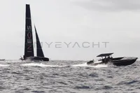 A Fabio Buzzi FB 38/19 S powerboat cruising alongside a sailboat on open water.