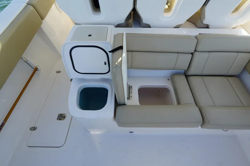 Yacht Photos Pics 2016 Pursuit ST 310 Sport boat interior with beige seating and storage compartments.