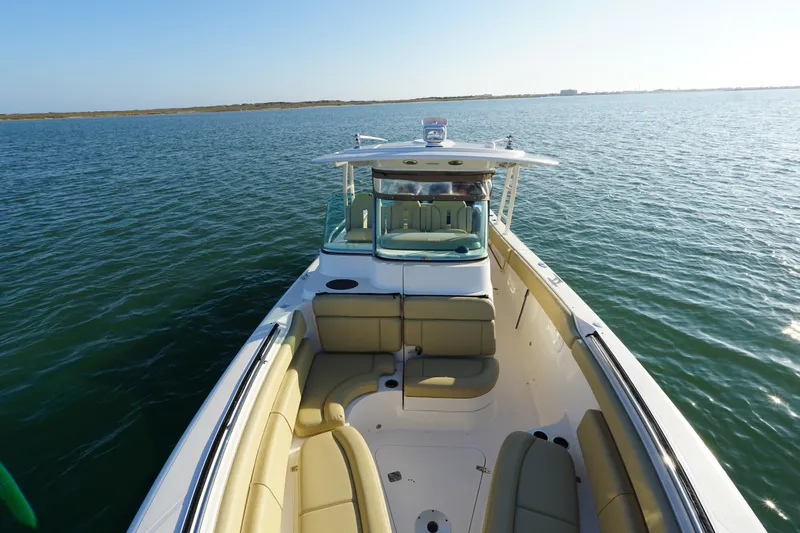  Yacht Photos Pics 2016 Pursuit ST 310 Sport boat on calm water, featuring spacious seating and sleek design.