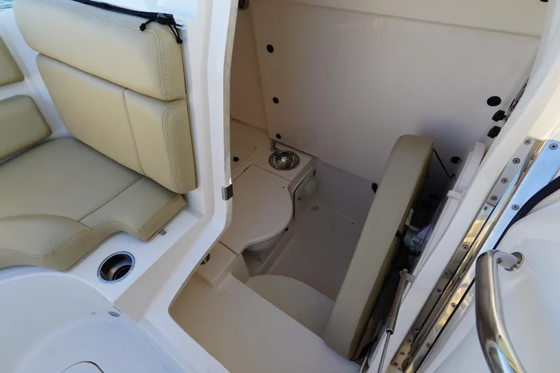  Yacht Photos Pics 2016 Pursuit ST 310 Sport boat interior with beige seating and compact restroom.