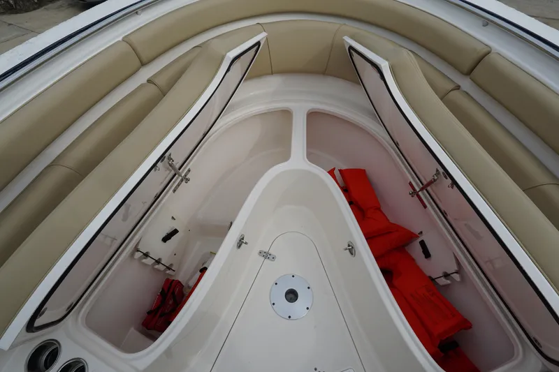  Yacht Photos Pics 2016 Pursuit ST 310 Sport boat interior with open storage compartments and life jackets.