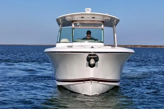  Yacht Photos Pics 2016 Pursuit ST 310 Sport boat cruising on open water, front view.