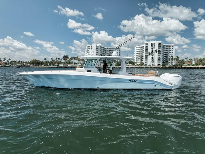 Mo Jack Yacht Photos Pics 2022 HCB Lujo boat cruising on water with cityscape background.