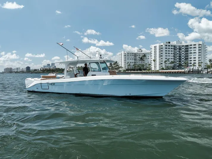 Mo Jack Yacht Photos Pics 2022 HCB Lujo boat cruising on water near city skyline under blue sky.