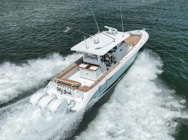 Mo Jack Yacht Photos Pics 2022 HCB Lujo boat cruising on water with triple outboard engines.