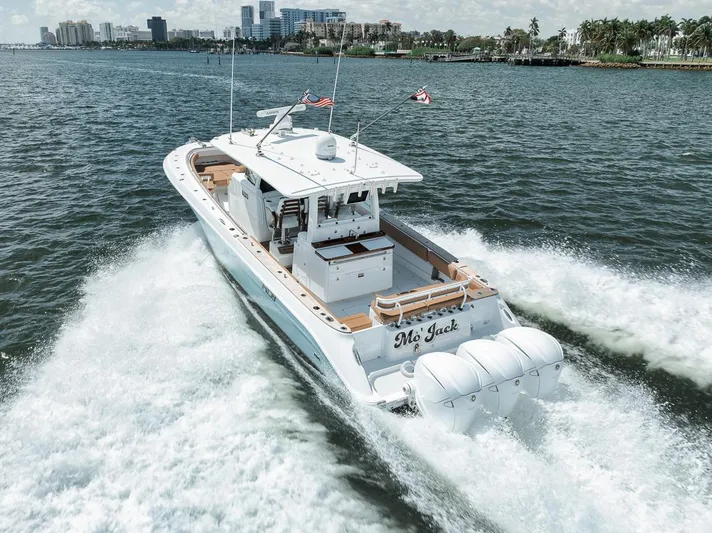 Mo Jack Yacht Photos Pics 2022 HCB Lujo boat cruising on water with city skyline in background.