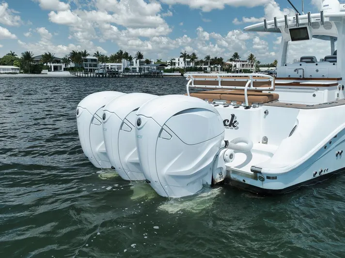 Mo Jack Yacht Photos Pics 2022 HCB Lujo boat with triple outboard engines on a sunny day.