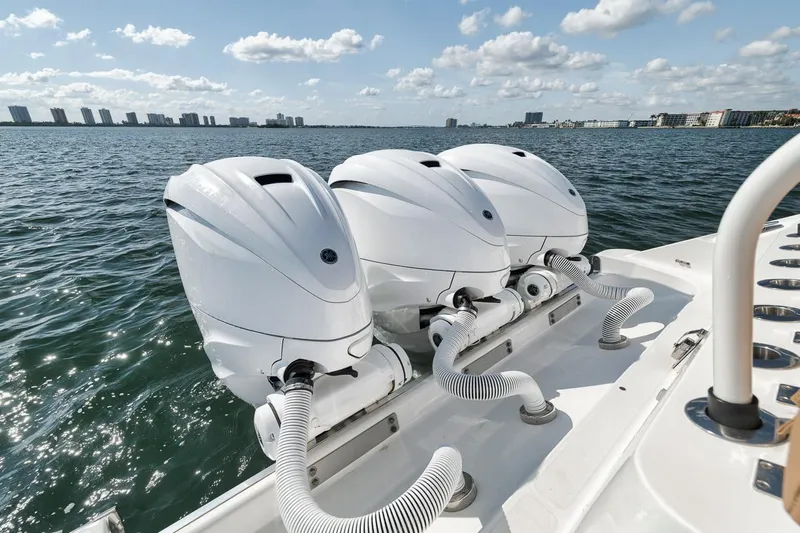 Mo Jack Yacht Photos Pics Triple outboard engines on a 2022 HCB Lujo boat, cruising on a sunny day.