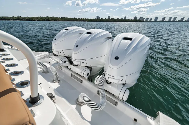 Mo Jack Yacht Photos Pics Triple outboard engines on a 2022 HCB Lujo boat, cruising on a sunny day.