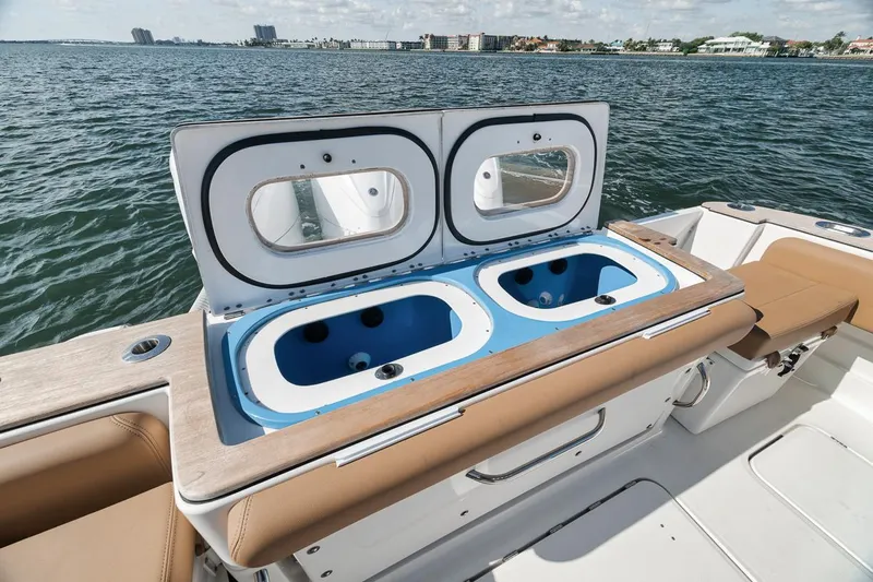 Mo Jack Yacht Photos Pics 2022 HCB Lujo boat with dual livewells on deck, ocean view in background.