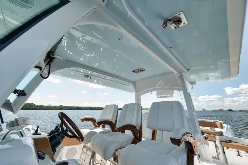 Mo Jack Yacht Photos Pics 2022 HCB Lujo boat interior with luxurious seating and steering, overlooking serene water.
