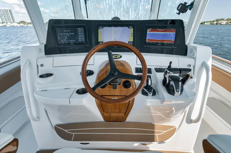 Mo Jack Yacht Photos Pics Helm of 2022 HCB Lujo boat with modern navigation displays and wooden steering wheel.