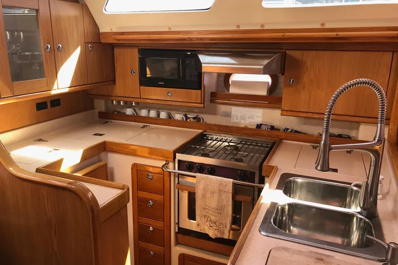 Charmed Life Yacht Photos Pics Interior of 2000 Catalina 470 yacht kitchen with wood cabinetry and modern appliances.