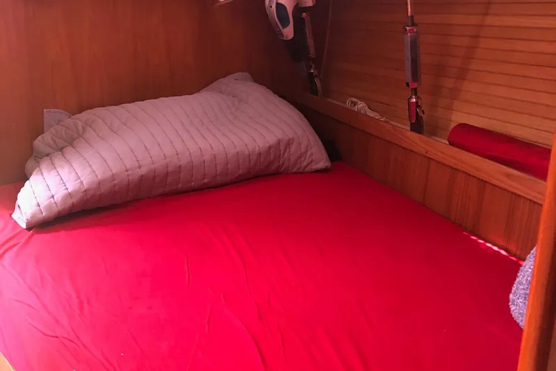Charmed Life Yacht Photos Pics Cozy cabin bed with red bedding in 2000 Catalina 470 sailboat.