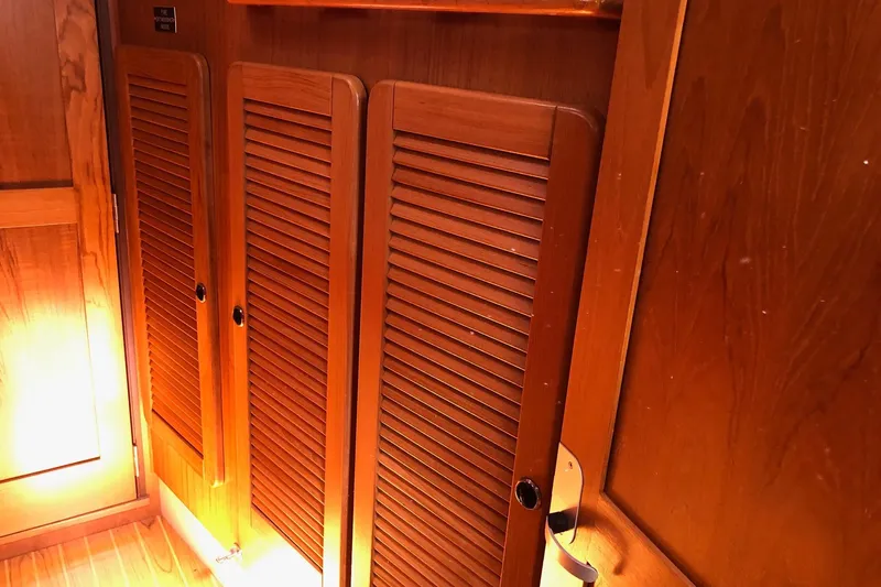 Charmed Life Yacht Photos Pics Wooden interior of a 2000 Catalina 470 sailboat, featuring louvered cabinet doors.