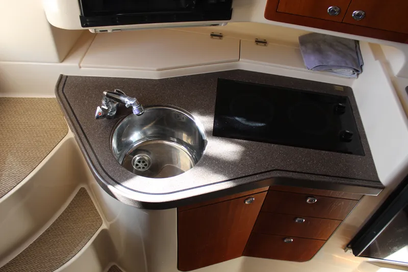 Tide Traveler Yacht Photos Pics Compact kitchen area in a 2008 Grady-White Express 330 boat with sink and stove.