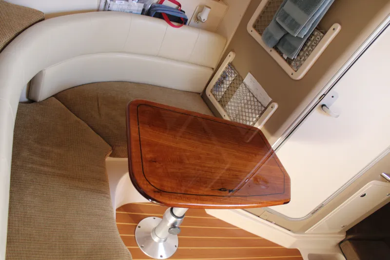 Tide Traveler Yacht Photos Pics 2008 Grady-White Express 330 cabin interior with wooden table and cushioned seating.