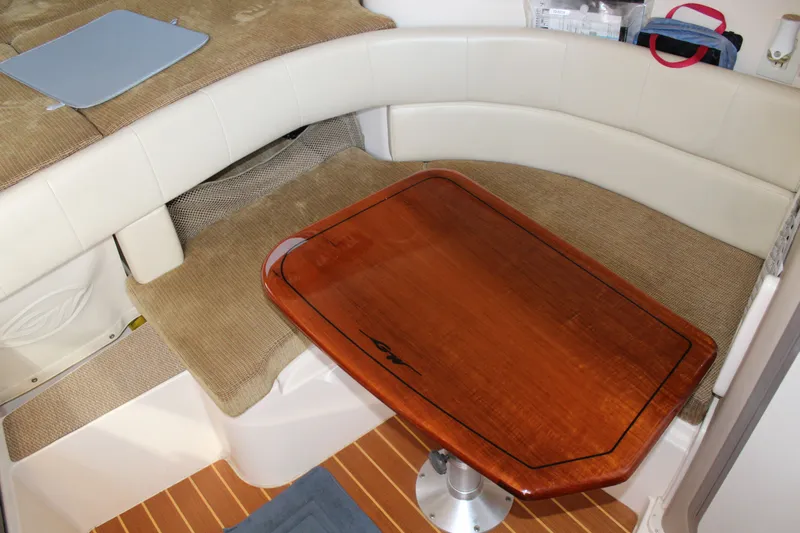 Tide Traveler Yacht Photos Pics 2008 Grady-White Express 330 cabin interior with wooden table and cushioned seating.