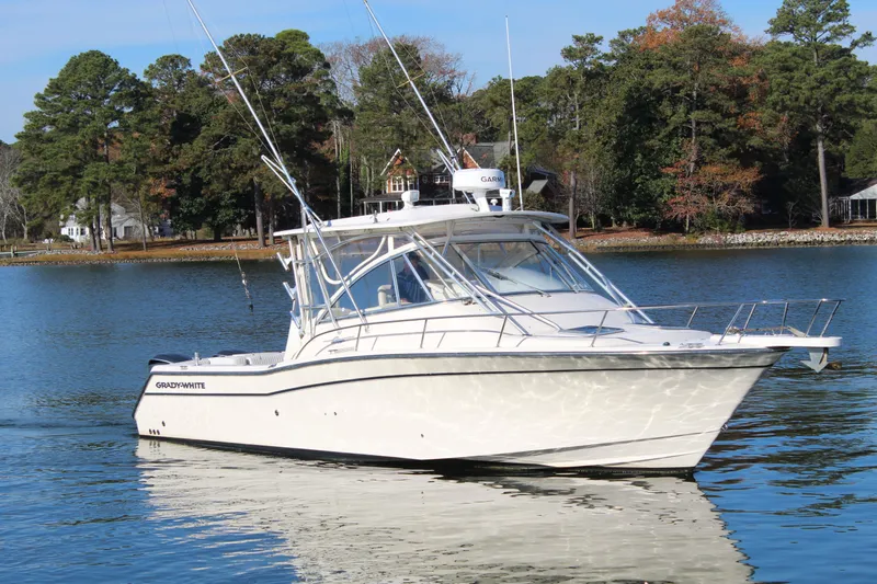 Tide Traveler Yacht Photos Pics 2008 Grady-White Express 330 boat on a serene lake with trees in the background.