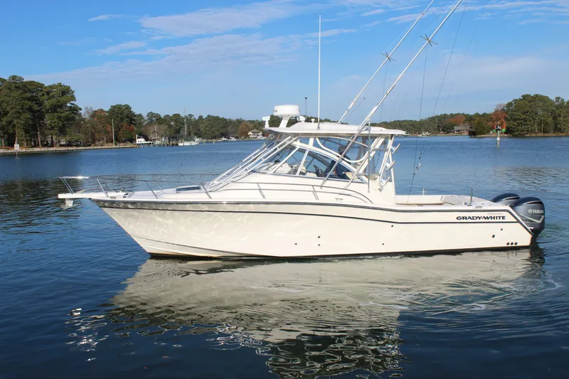 Tide Traveler Yacht Photos Pics 2008 Grady-White Express 330 boat on a calm lake with trees in the background.