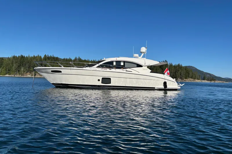 Dolce Far Niente Yacht Photos Pics 2012 Maritimo C53 Sports Cabriolet yacht on serene water with forested background.